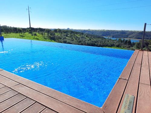 米尔芳提斯城Naturarte Rio - Duna Parque Group的一个带木甲板和蓝色海水的游泳池