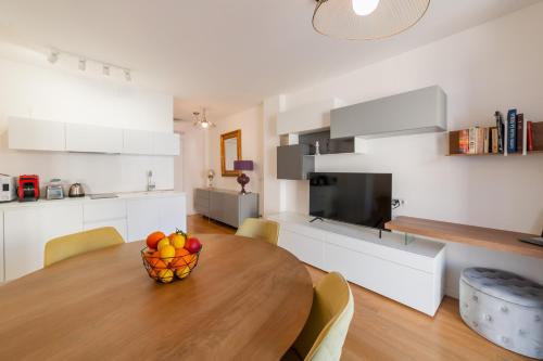 陶尔米纳Castalia Apartments & Rooms Duomo Taormina的厨房以及带木桌和一碗水果的用餐室。