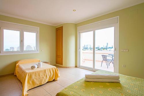 卡尔佩Villa Almendros - PlusHolidays的一间卧室设有两张床和大窗户