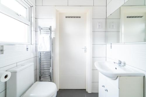 伦敦(Kensington-Olympia-Museums ) Apartment Central London的白色的浴室设有卫生间和水槽。