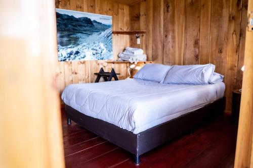 GüicánHotel Casa del Colibri的木制客房内的一间卧室,配有一张床