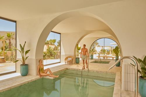 圣安东尼奥The Signature Level at TRS Ibiza Hotel All Inclusive Adults Only的坐在游泳池里的男人和女人