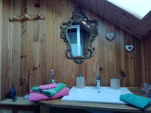 Le NoyerLa Grange的浴室设有水槽和木墙镜子