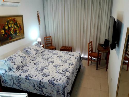 伊利亚贝拉Suítes Cambucá的卧室配有一张床和一张桌子及椅子