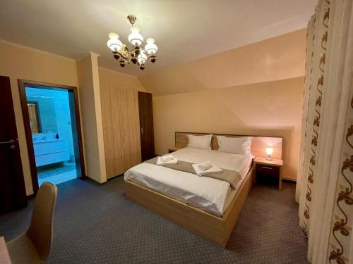 卡夫尼克Casa Iulian的一间卧室配有一张床和一个吊灯