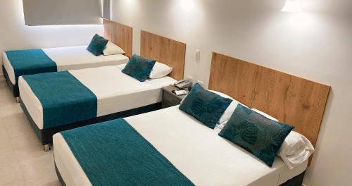 布卡拉曼加Hotel Ruittoque D Prada的一间设有三张蓝色和白色床铺的房间