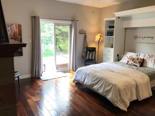 伦敦Cozy Luxury on the Thames in Ontario!的一间卧室设有一张床和一个滑动玻璃门