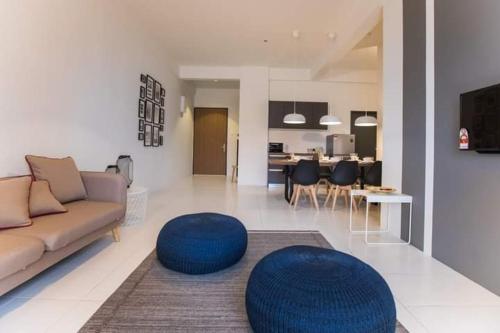 阿罗士打Imperio Professional Suite by 188AOR的带沙发和蓝色凳子的客厅
