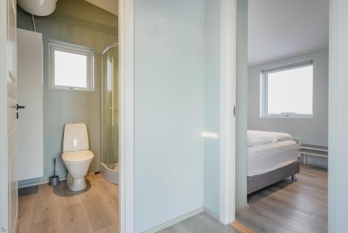 塞尔福斯Sula Guesthouse的一间带卫生间的浴室和一张位于客房内的床。