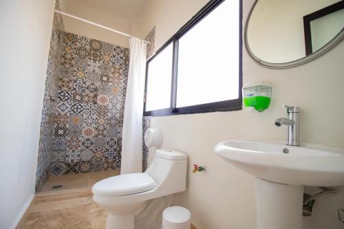 奥里萨巴Hostal 170的一间带卫生间、水槽和镜子的浴室