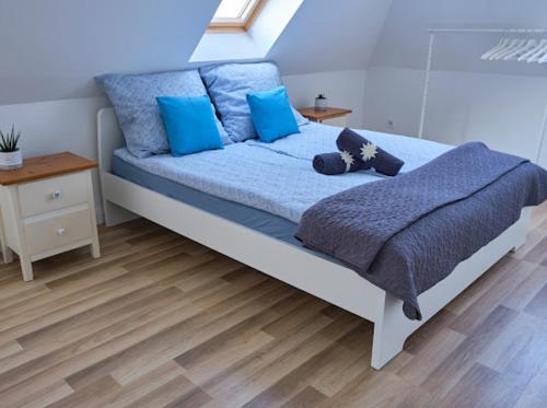 福纽德Strand Apartman的一间卧室配有一张带蓝色床单和蓝色枕头的床。