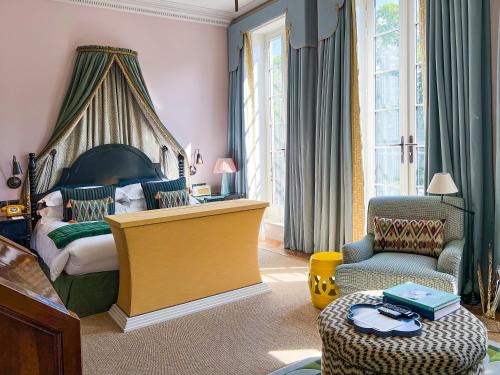 伦敦Beaverbrook Town House的一间卧室配有一张大床和一把椅子