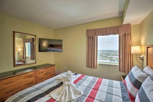默特尔比奇Bayview Resort Penthouse w/ Sunset Views的一间卧室配有带梳妆台和窗户的床。