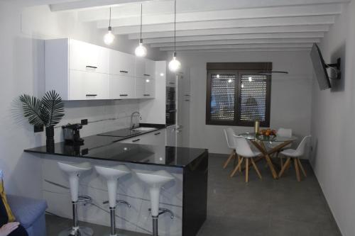 Villar de CanesCASA RURAL MENSIN的厨房配有黑色柜台和白色橱柜