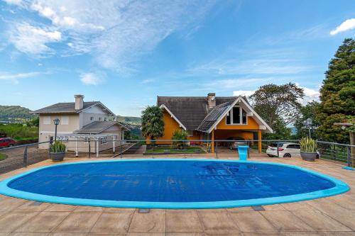 格拉玛多Rosa Casa Várzea Grande的一座大蓝色游泳池,位于房子前