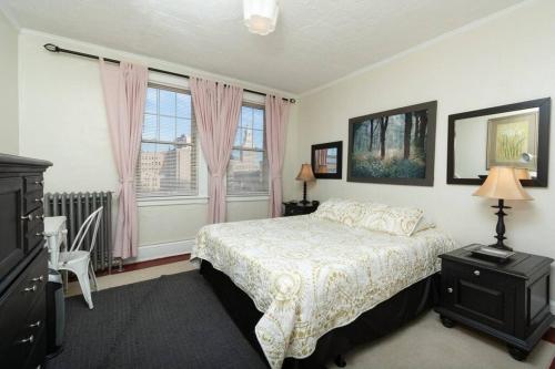 哈特福德The Traveler Suite C1的一间卧室配有床和一个带粉红色窗帘的窗户。