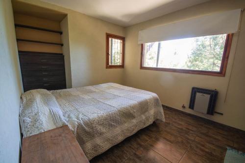 圣卡洛斯-德巴里洛切casa con vista al lago的一间卧室设有一张床和一个窗口
