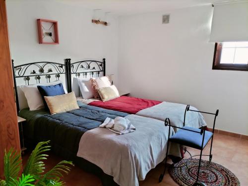 丰卡连特德拉帕尔马El Somadero B的一间卧室配有一张床和一把椅子