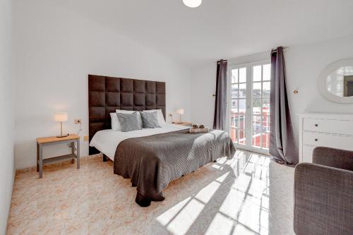 圣胡安海滩Bonita Casa Nina con Jacuzzi By Paramount Holidays的白色的卧室设有一张大床和一个窗户