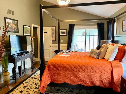 滨湖尼亚加拉探险者之家住宿加早餐旅馆的一间卧室配有橙色的床和电视