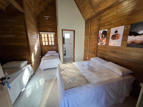 德尔菲诺波利斯Pousada Canastra Sul的木墙客房的两张床