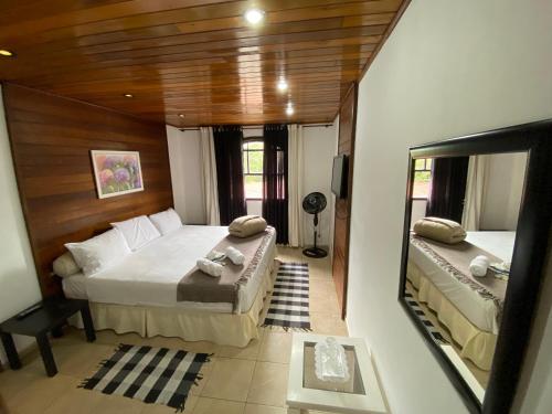 彼得罗波利斯Casa Petrópolis的一间卧室设有两张床和大镜子