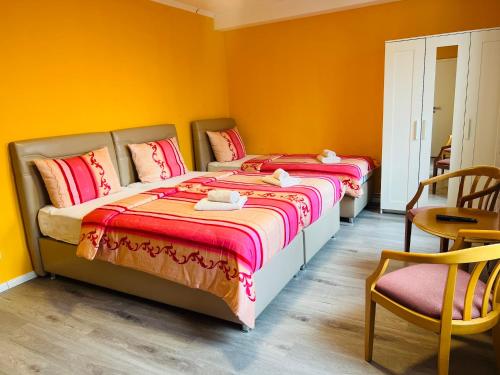 汉堡M&M Hotel - Wilhelmsburg的黄色墙壁客房的两张床