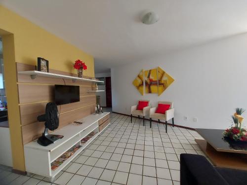 马塞约Apartamento na praia de Jatiuca的带电视的客厅和瓷砖地板。