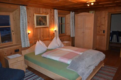多比亚科Gostnerhof的木制客房内的一间卧室,配有一张床