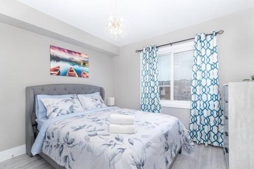 埃德蒙顿Modern & Stylish 1-Bedroom Unit的一间卧室配有一张带蓝色窗帘的床和一扇窗户