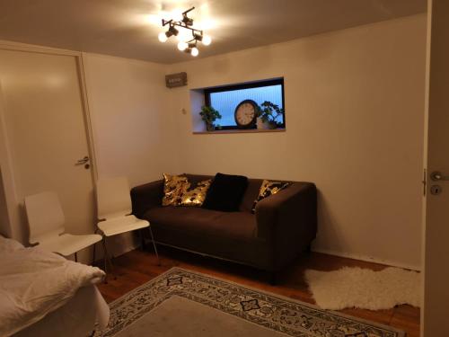 厄勒布鲁Ett rums lägenhet med egen ingång, parkering的客厅配有沙发和墙上的时钟