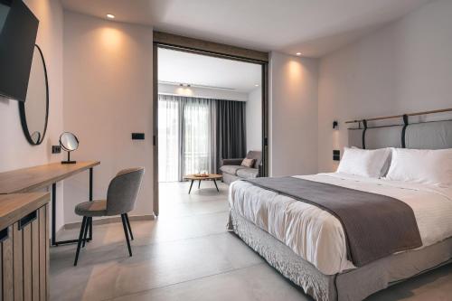尼基季Lagomandra Luxury Suites with Private Pools的一间卧室配有一张床、一张桌子和一张沙发