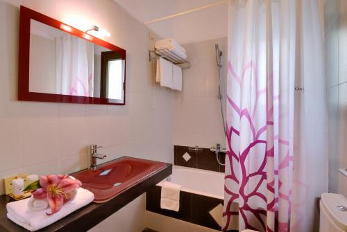 利昂尼迪翁拜赞蒂农酒店的一间带红色水槽和镜子的浴室