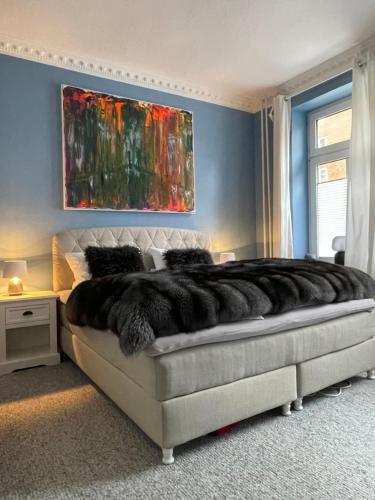 基尔Luxus Altbaucharme in zentraler Lage的卧室配有一张大床,墙上挂有绘画作品