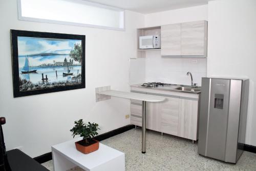 巴兰基亚Eslait Hotel & Apartamentos的白色的厨房配有水槽和桌子