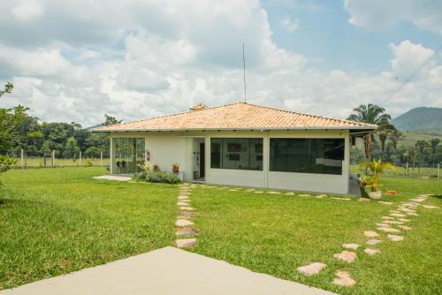 戈亚斯州上帕莱索EIT Eco Inteligente的一座带草地庭院的白色小房子