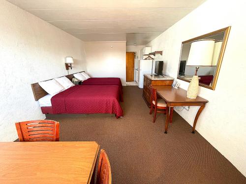 北怀尔德伍德Cardinal Motel的酒店客房配有红色的床和书桌