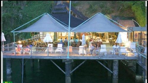 萨尔瓦多Sol Vicitoria Marina的水面上带桌椅和遮阳伞的码头