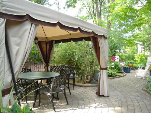 魁北克市拉维典奎特咖啡馆及酒店的帐篷下配有桌椅的天井