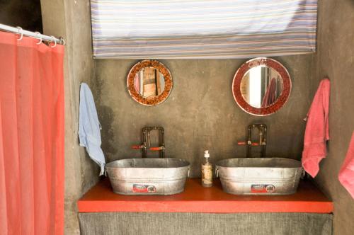 拉巴斯Sunset Hostel的浴室设有2个水槽和2个镜子
