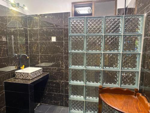 西哈努克Villa Blue Lagoon的浴室设有玻璃墙和葡萄酒瓶