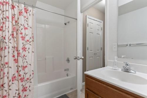 曼哈顿King Bed, Garage and Free Parking, Walkout Deck KMN1212的浴室配有水槽和带浴帘的淋浴