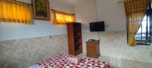 八丹拜和谐旅馆的一间卧室配有一张床和一台电视。