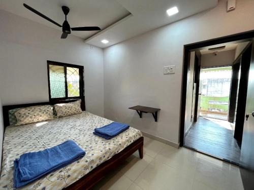 拉特纳吉里Gayatri Homestay的一间卧室配有一张带蓝色毛巾的床
