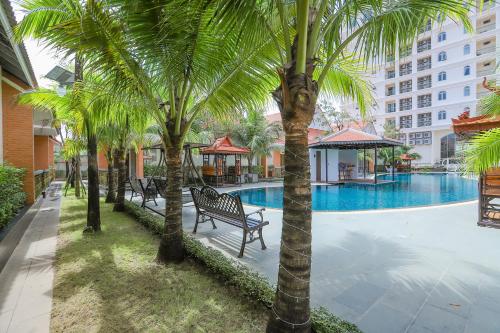 西哈努克Sea Breeze Hotel & Villa的一组棕榈树,毗邻一个游泳池