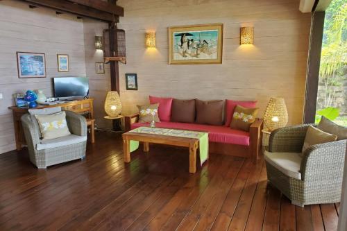 哈皮蒂Cottage Miti Reva的客厅配有红色的沙发和两把椅子