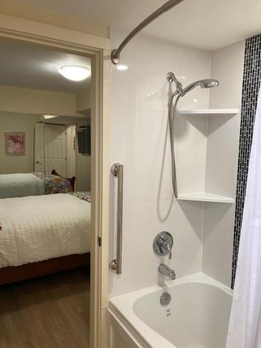彭蒂克顿Bright poolside walkout two bedroom basement suite in the Okanagan的带淋浴和盥洗盆的浴室以及1张床。