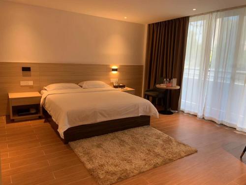 广州广州纺园公寓酒店的一间卧室设有一张大床和一个大窗户