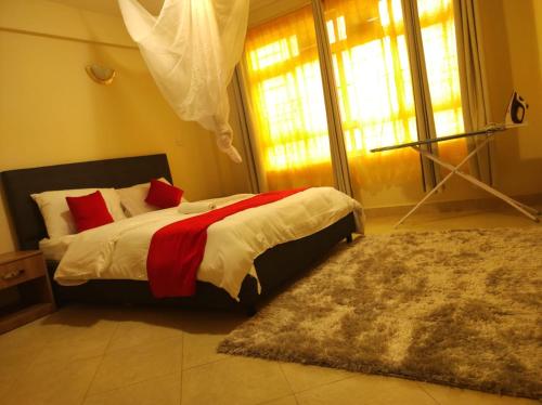 KakamegaMusundi Luxury Homes的一间卧室配有一张带红色枕头和地毯的床