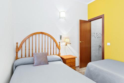 巴塞罗那亚圣安娜旅馆的一间卧室设有两张床和淋浴。